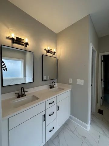a bathroom with a double vanity sink and mirror