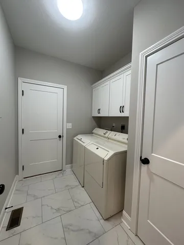 a utility room with cabinets washer and dryer