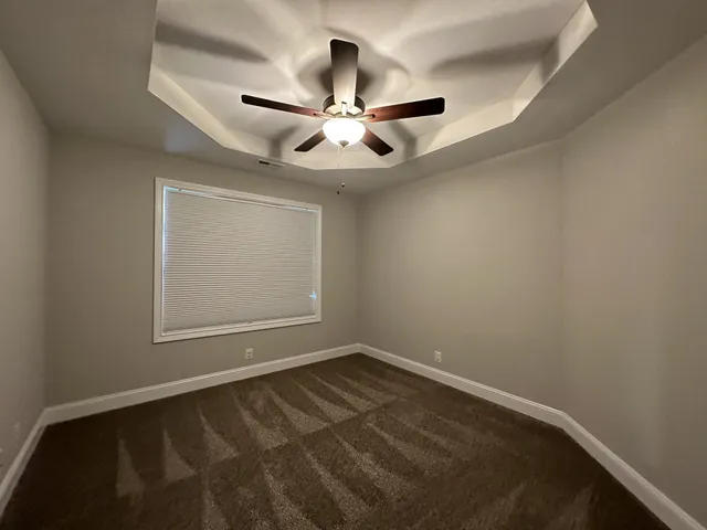 en empty room with windows and ceiling fan