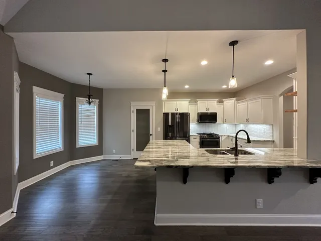 a large kitchen with kitchen island a large counter space and stainless steel appliances