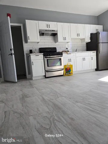 a kitchen with stainless steel appliances a stove a refrigerator a sink and a counter