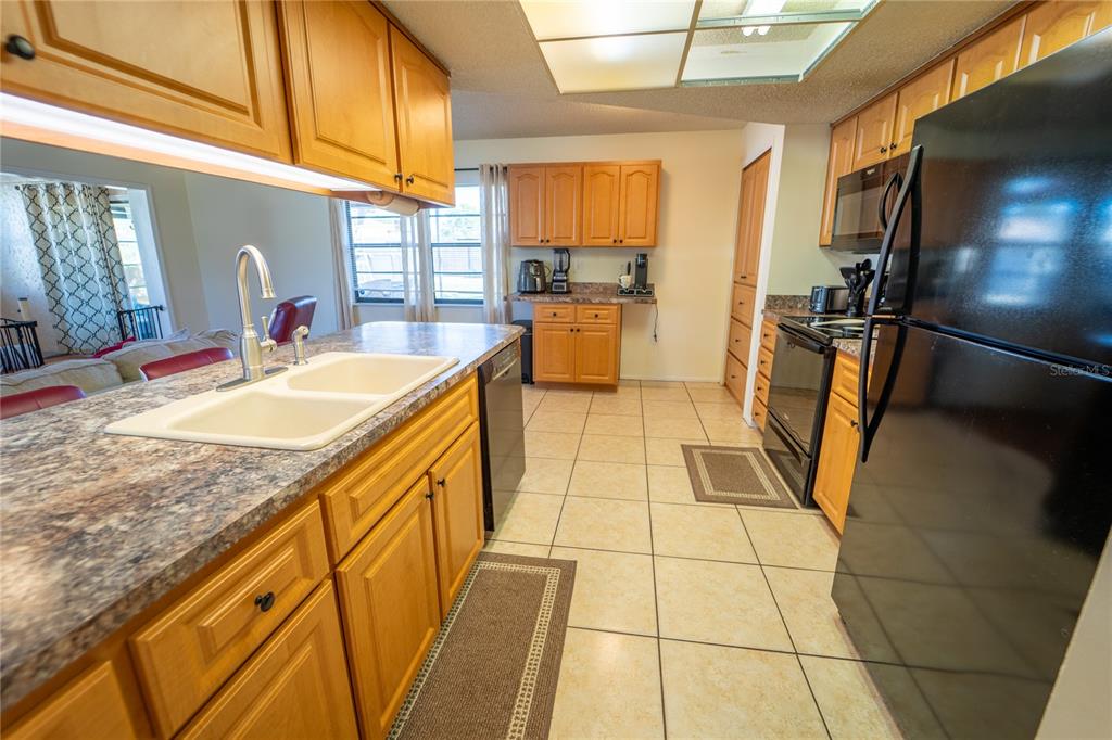1394 Escobar Avenue Spring Hill, FL 34608 - Photo 11 of 47 a kitchen with stainless steel appliances granite countertop a sink and cabinets