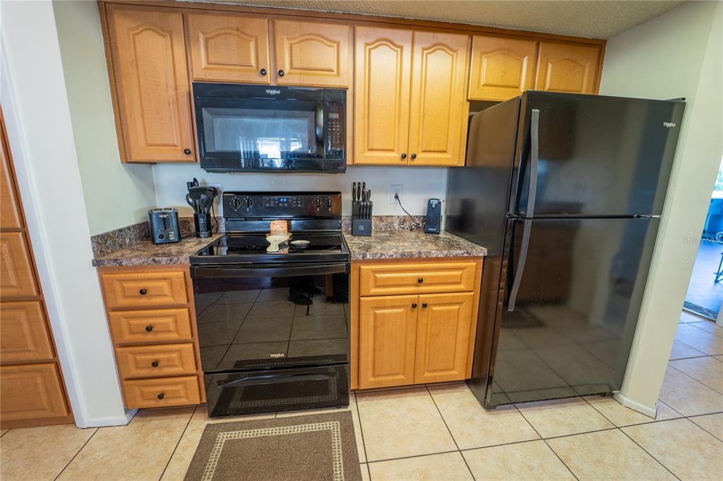 1394 Escobar Avenue Spring Hill, FL 34608 - Photo 14 of 47 a kitchen with a refrigerator and a stove