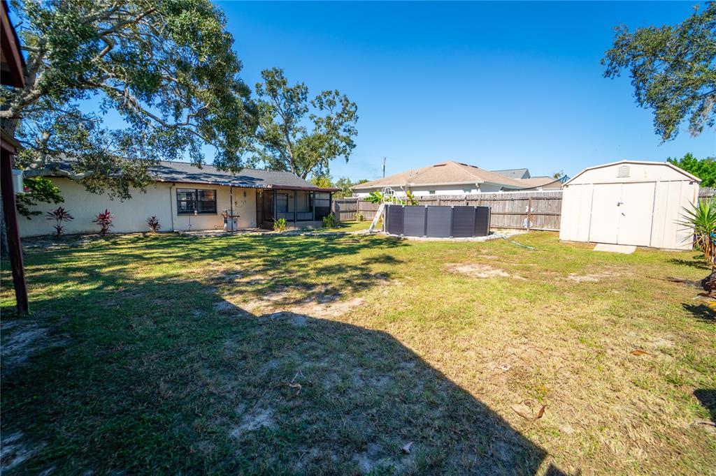 1394 Escobar Avenue Spring Hill, FL 34608 - Photo 31 of 47 a view of a house with a big yard and large tree