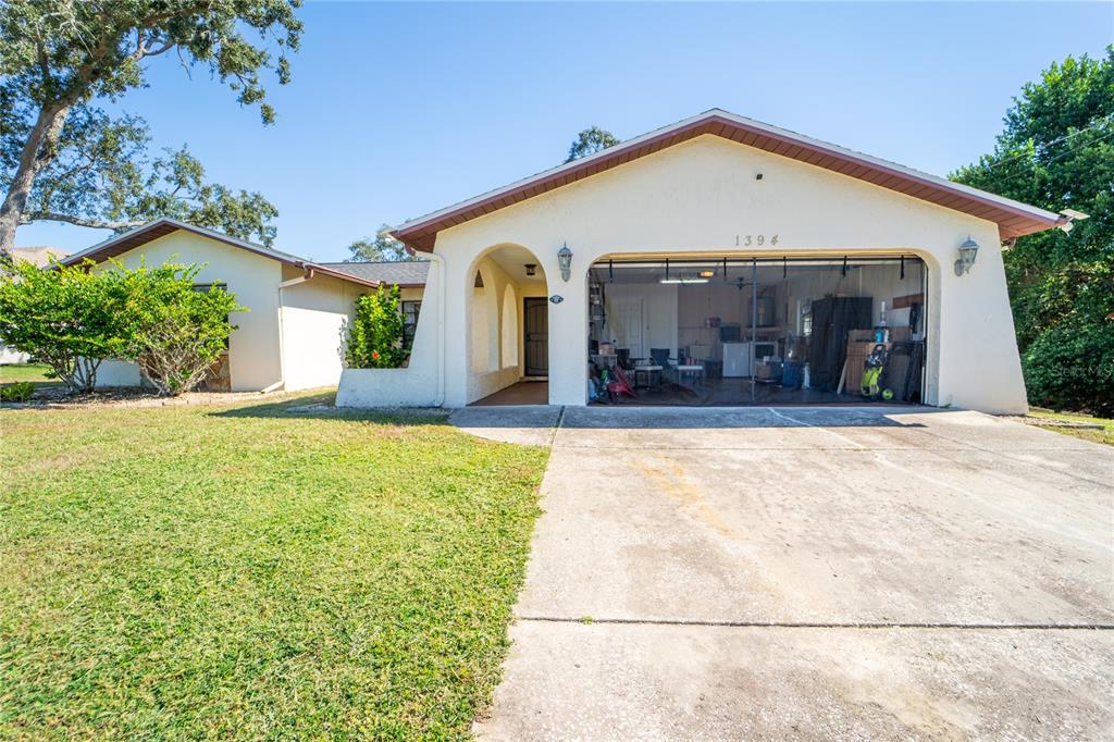 1394 Escobar Avenue Spring Hill, FL 34608 - Photo 45 of 47 a front view of a house with a yard and potted plants