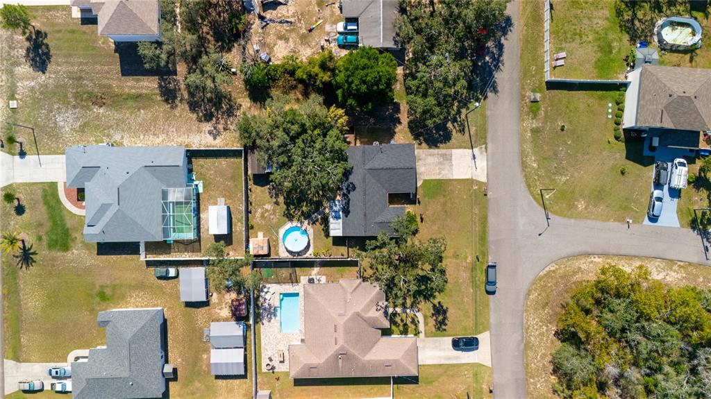 1394 Escobar Avenue Spring Hill, FL 34608 - Photo 7 of 47 aerial view of a house with swimming pool and large trees