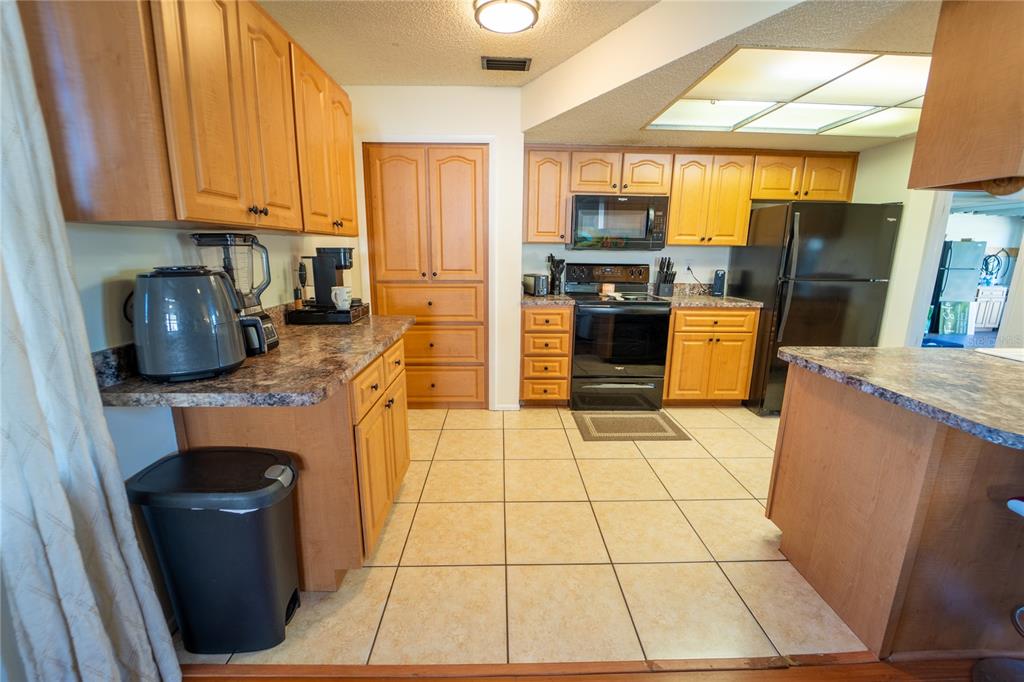 1394 Escobar Avenue Spring Hill, FL 34608 - Photo 10 of 47 a kitchen with stainless steel appliances granite countertop a stove a sink a refrigerator a microwave oven and a refrigerator