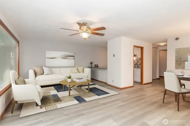 a living room with furniture a table and wooden floor