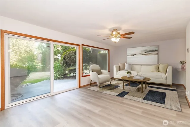 a living room with furniture two large windows and a chandelier
