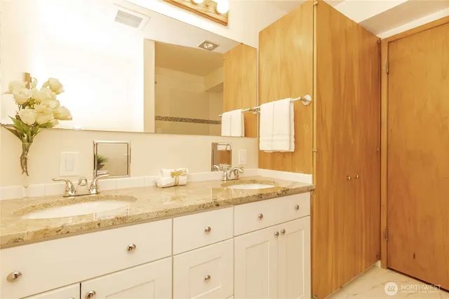 a bathroom with a granite countertop sink and a mirror
