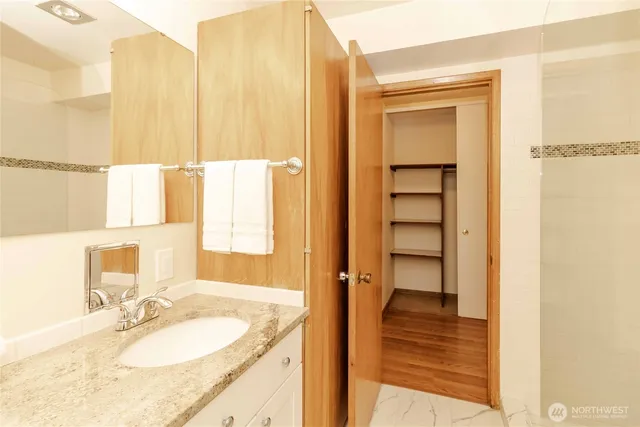 a bathroom with a granite countertop sink and a mirror