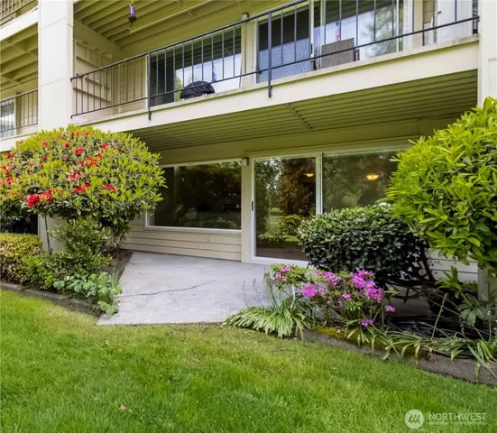 a front view of a house with a yard and potted plants