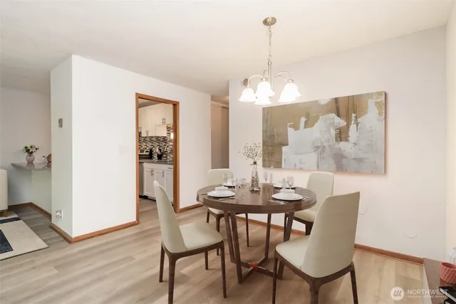 a dining room with furniture a chandelier and wooden floor