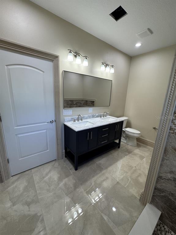 8351 Southwest 14th Lane Okeechobee, FL 34974 - Photo 29 of 46 a bathroom with a sink a toilet and mirror