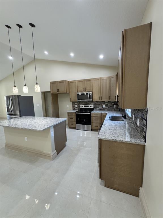 8351 Southwest 14th Lane Okeechobee, FL 34974 - Photo 43 of 46 a large kitchen with kitchen island a large counter top stainless steel appliances and cabinets