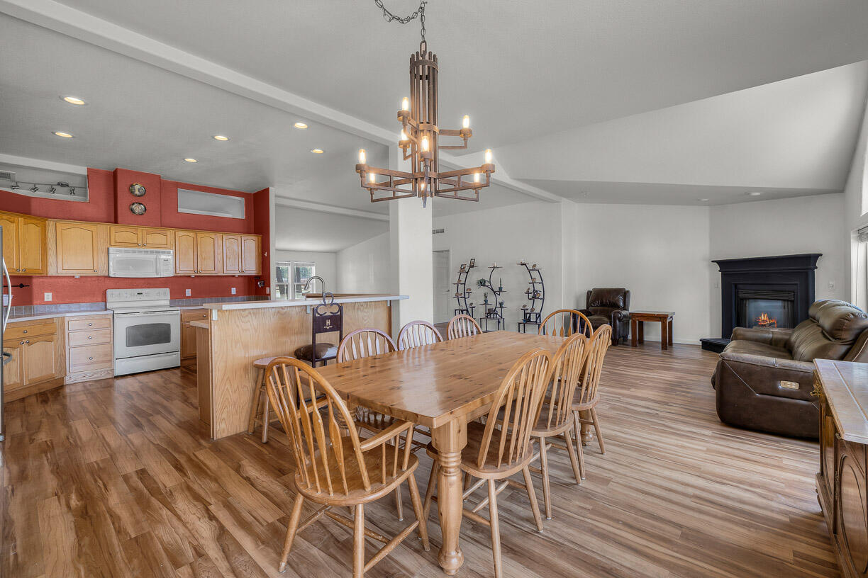 67500 Harrington Loop Road Bend, OR 97703 - Photo 12 of 72 a dining room with furniture a chandelier and wooden floor