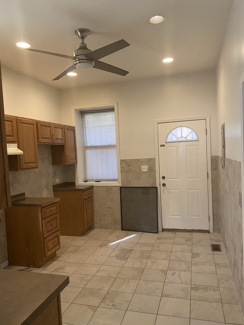 6424 South Morgan Street, Unit 1 Chicago, IL 60621 - Photo 3 of 7 a kitchen with granite countertop a refrigerator and a stove top oven