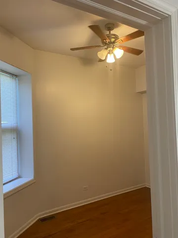 a view of a small space with wooden floor and a window