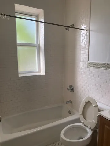 a white bath tub sitting next to a toilet