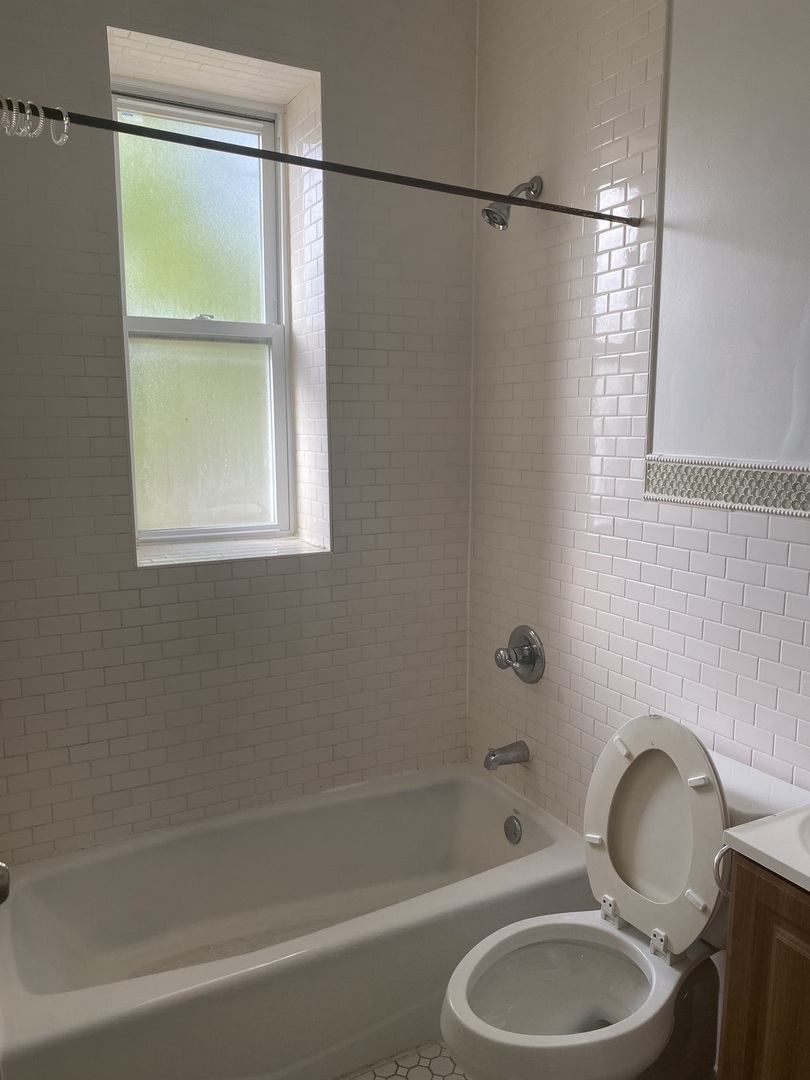 6424 South Morgan Street, Unit 1 Chicago, IL 60621 - Photo 7 of 7 a white bath tub sitting next to a toilet