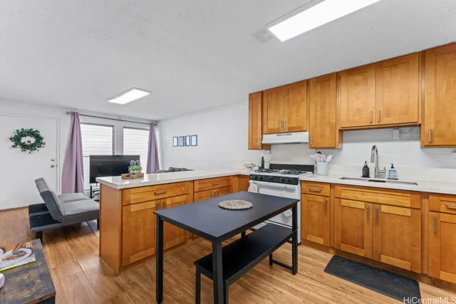 a kitchen with a stove a sink a dining table and chairs