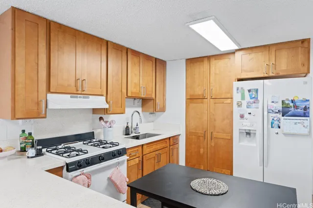 a kitchen with stainless steel appliances granite countertop a refrigerator and a stove top oven
