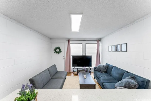 a living room with furniture a flat screen tv and a lamp