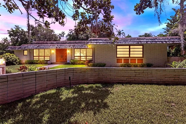 a front view of a house with a yard and lake view