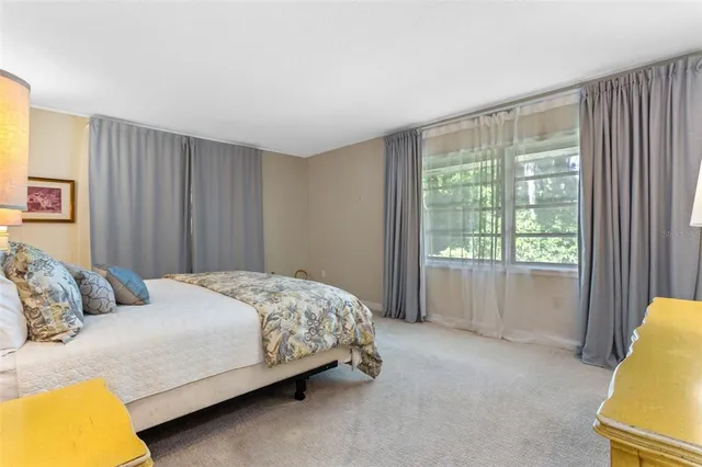 a spacious bedroom with a bed and glass window
