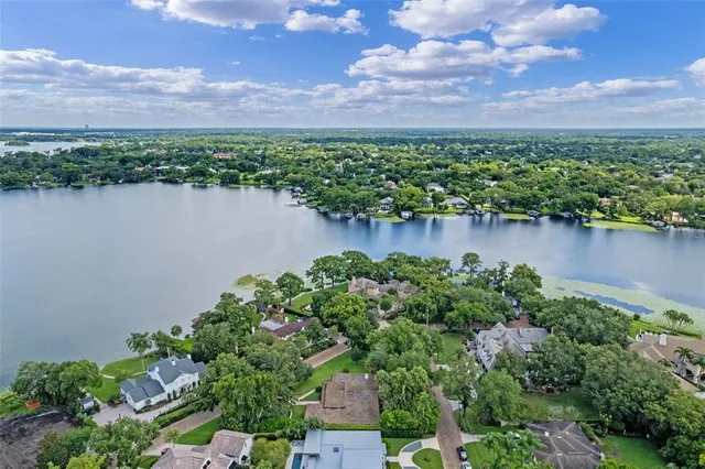an aerial view of a house with a yard and lake view
