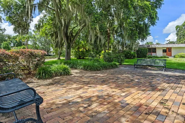 an aerial view of residential houses with outdoor space and trees