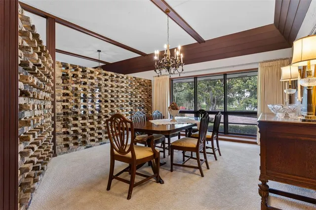 a view of a dining room with furniture a chandelier and large windows