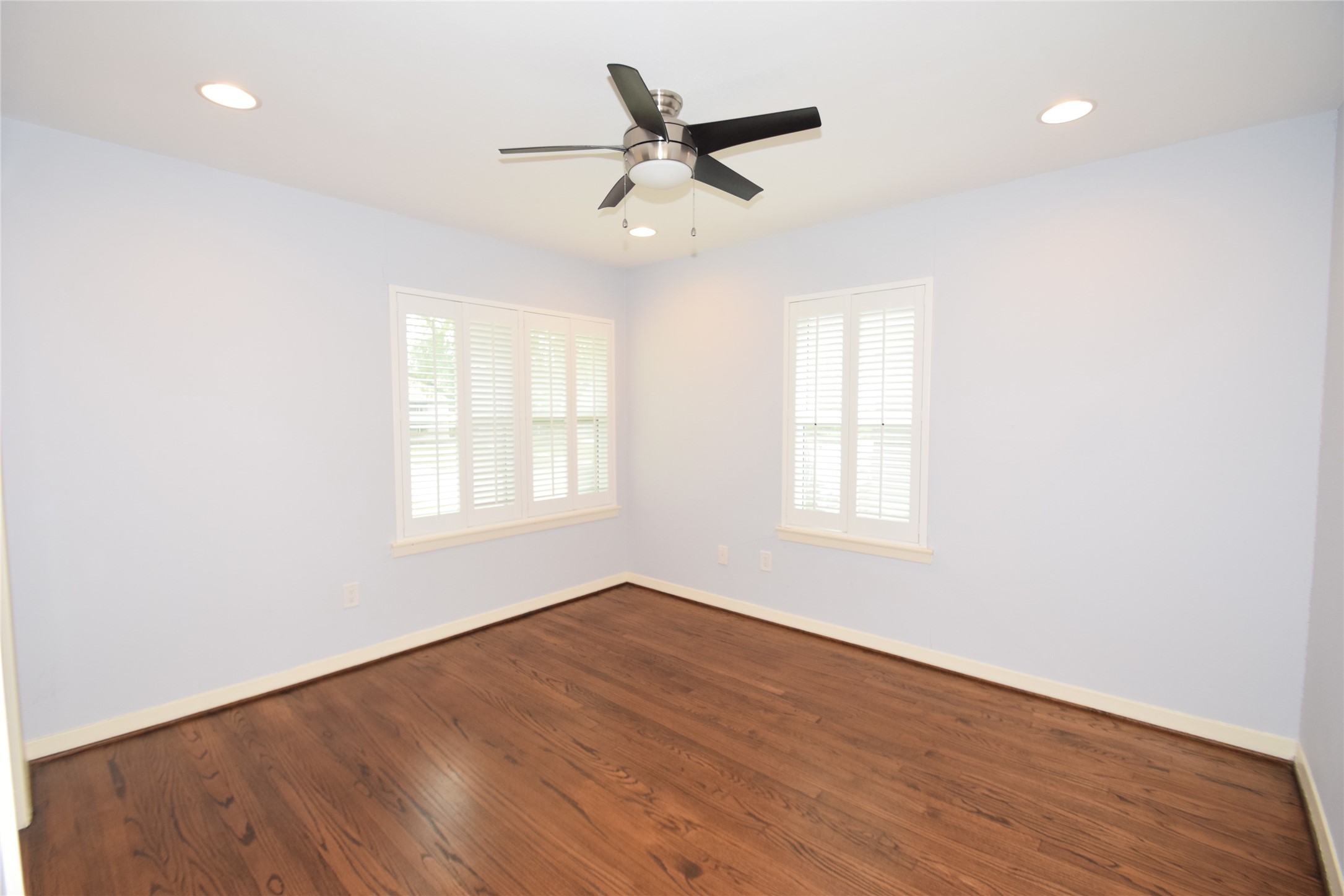 8434 Bluegate Street Houston, TX 77025 - Photo 21 of 28 an empty room with wooden floor fan and windows