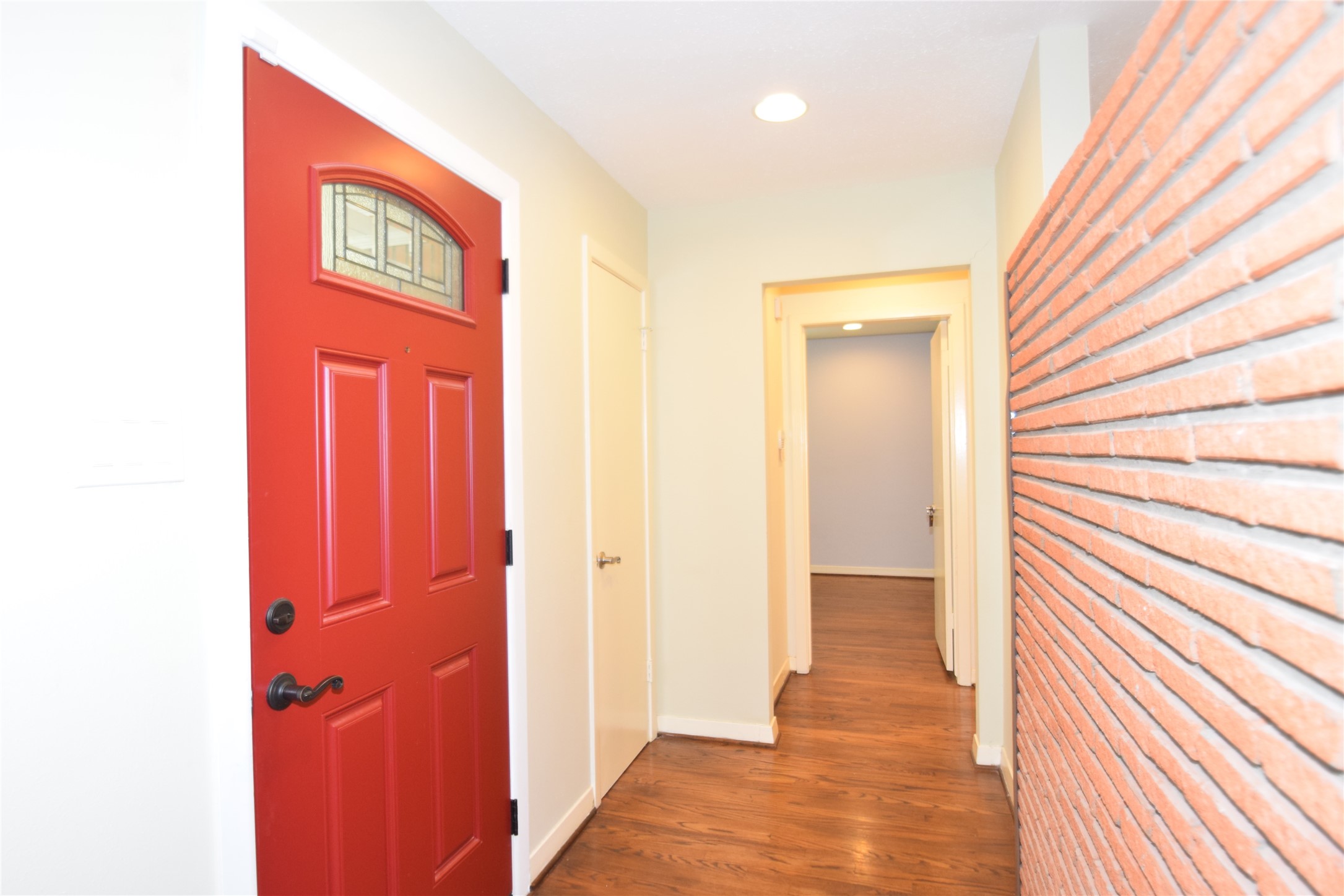 8434 Bluegate Street Houston, TX 77025 - Photo 3 of 28 a view of a hallway with wooden floor and a bathroom