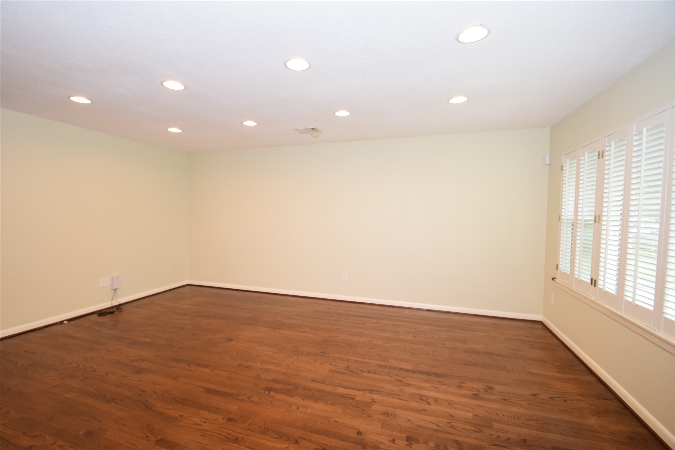 8434 Bluegate Street Houston, TX 77025 - Photo 4 of 28 an empty room with wooden floor and windows