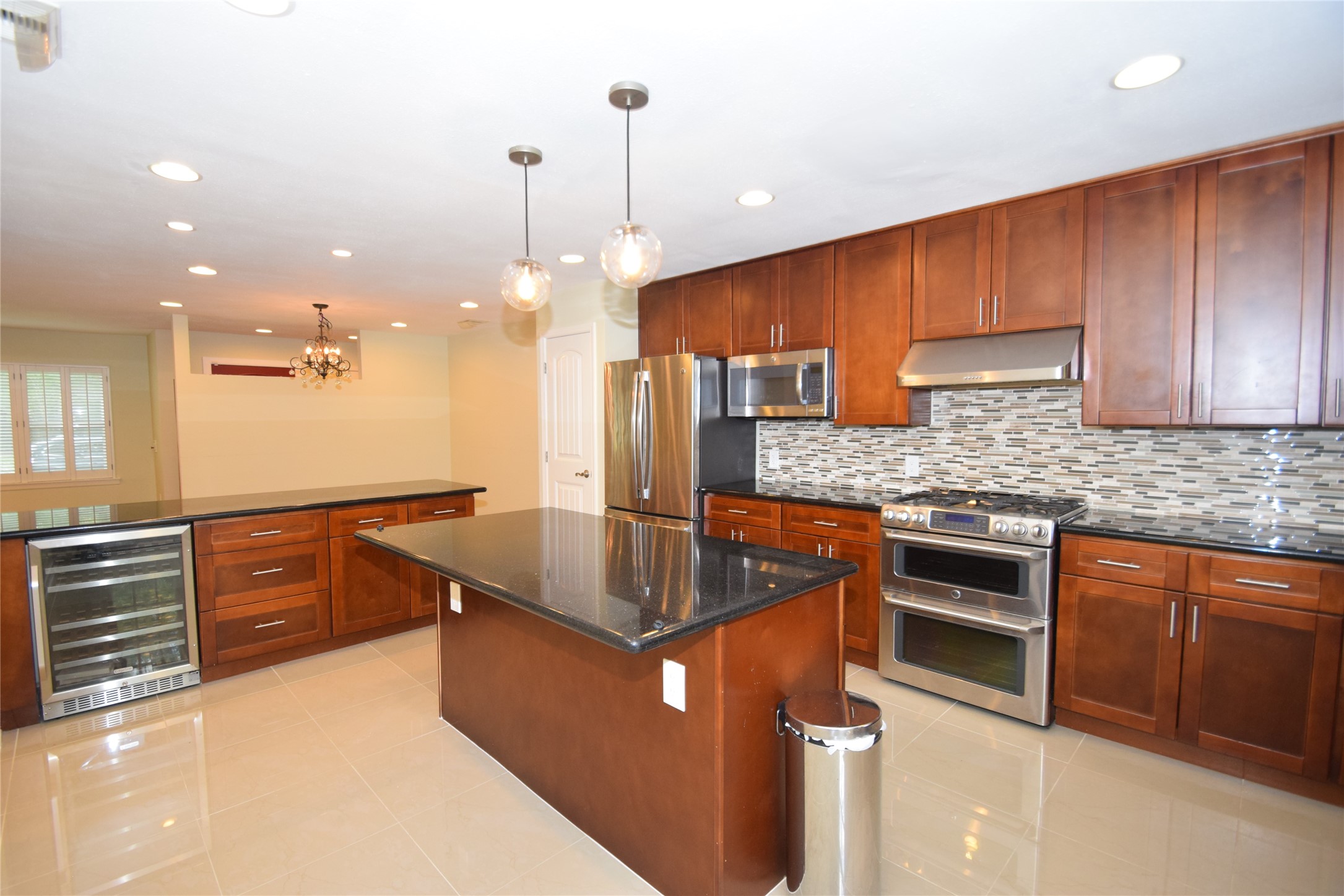8434 Bluegate Street Houston, TX 77025 - Photo 10 of 28 a kitchen with kitchen island granite countertop wooden cabinets and stainless steel appliances