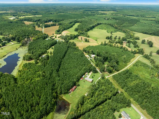 an aerial view of residential houses with outdoor space and trees