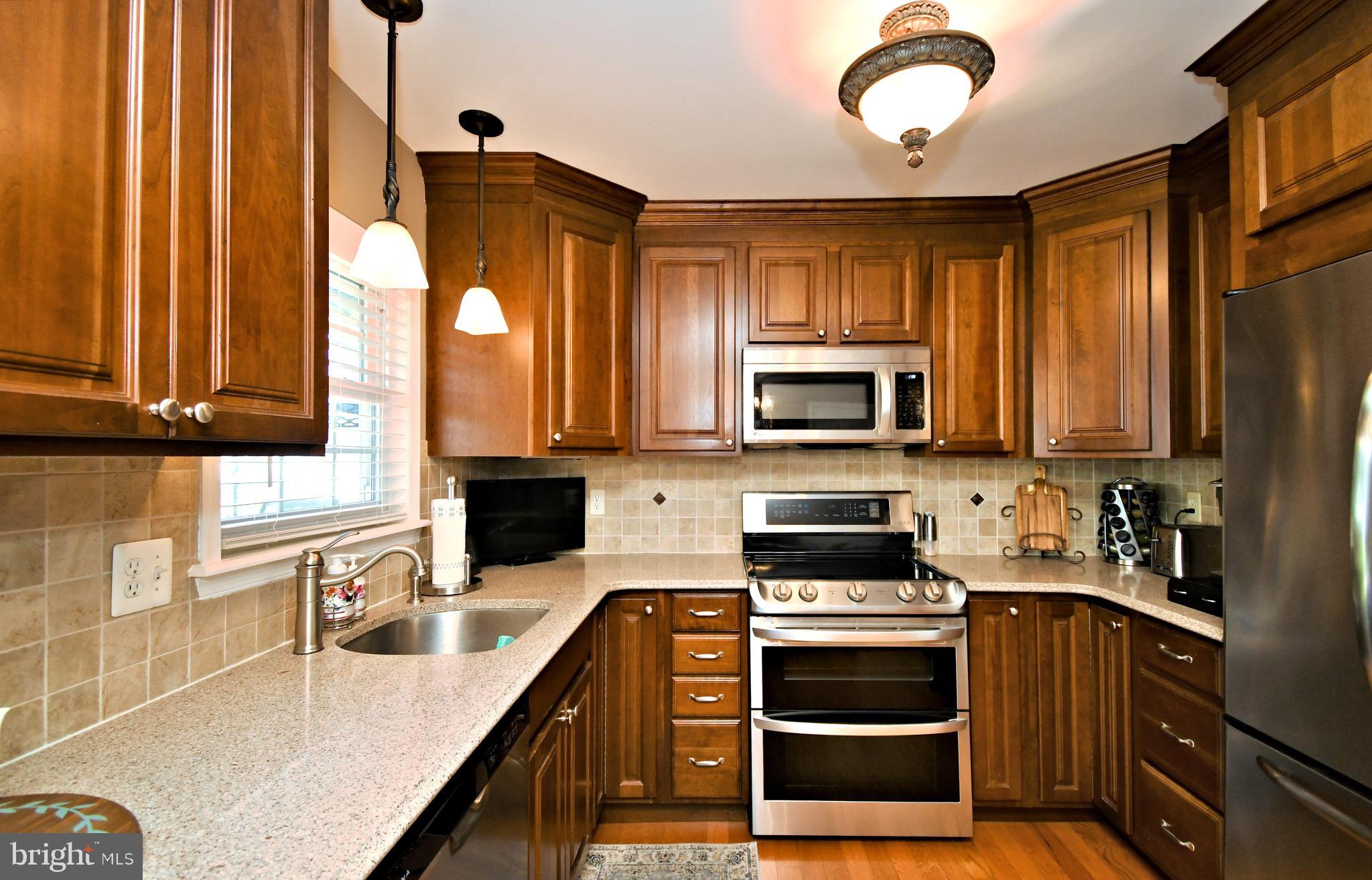 20 Conifer Road Levittown, PA 19057 - Photo 14 of 52 a kitchen with stainless steel appliances granite countertop a stove a sink and a microwave