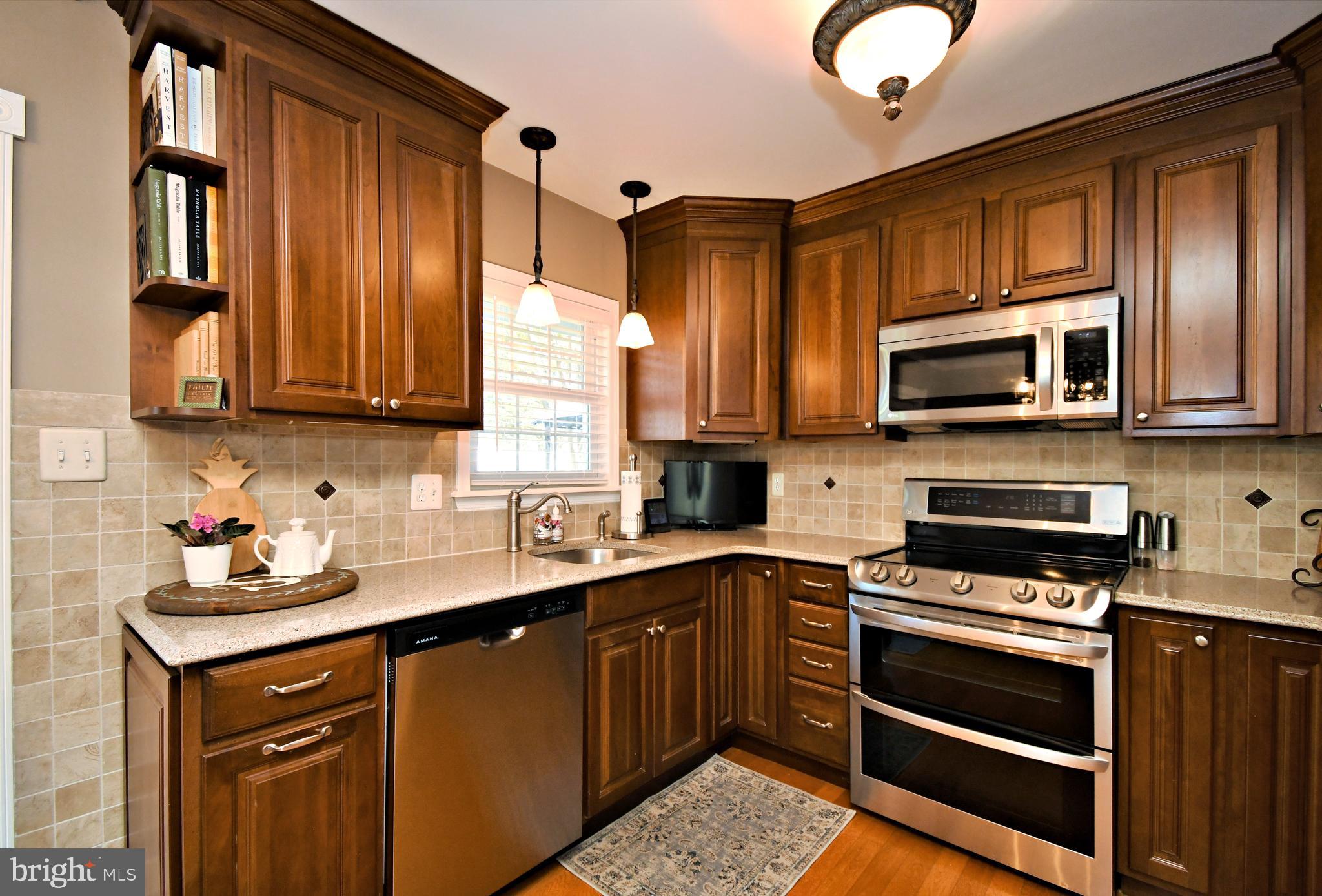 20 Conifer Road Levittown, PA 19057 - Photo 15 of 52 a kitchen with stainless steel appliances granite countertop wooden cabinets a stove top oven a sink and dishwasher