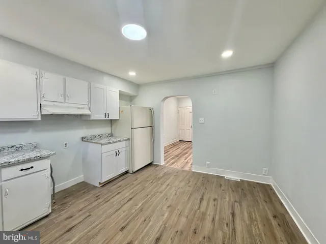a kitchen with cabinets and wooden floor