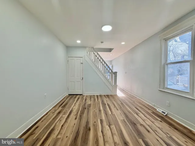 a view of an empty room with wooden floor