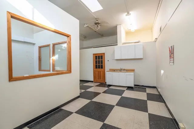 a view of a room with gym equipment and a rug