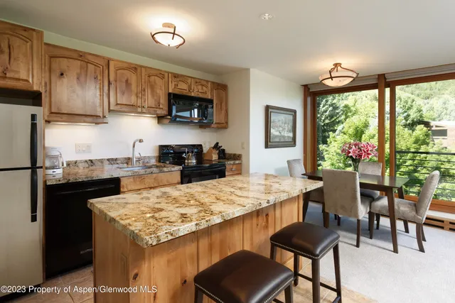 a kitchen with a stove a table and chairs in it