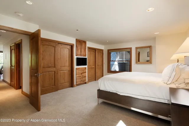 a spacious bedroom with a bed and a cabinets