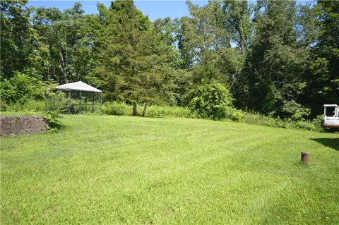 a backyard of a house with a yard and outdoor seating