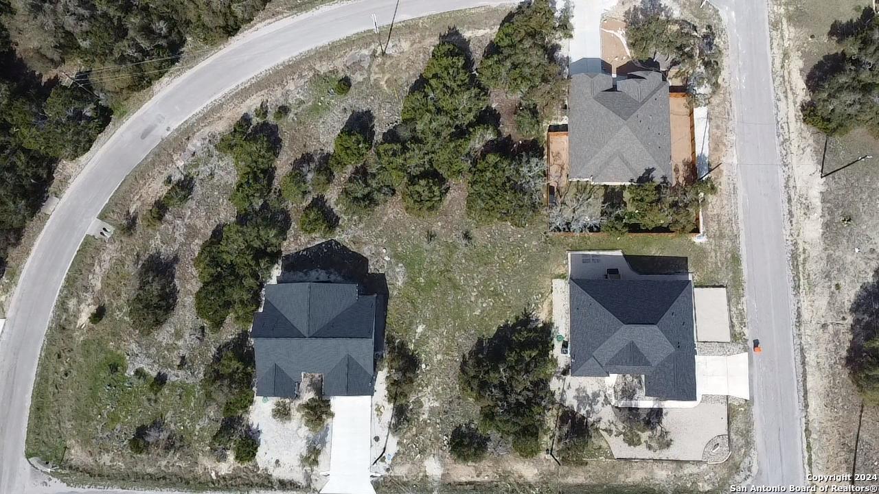 an aerial view of a house with a yard and large trees