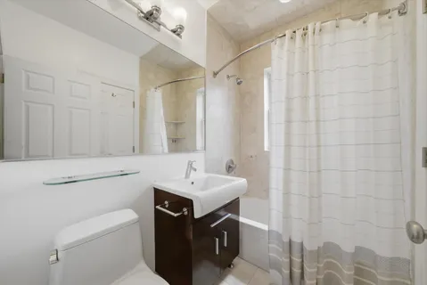 a bathroom with a sink toilet vanity and shower