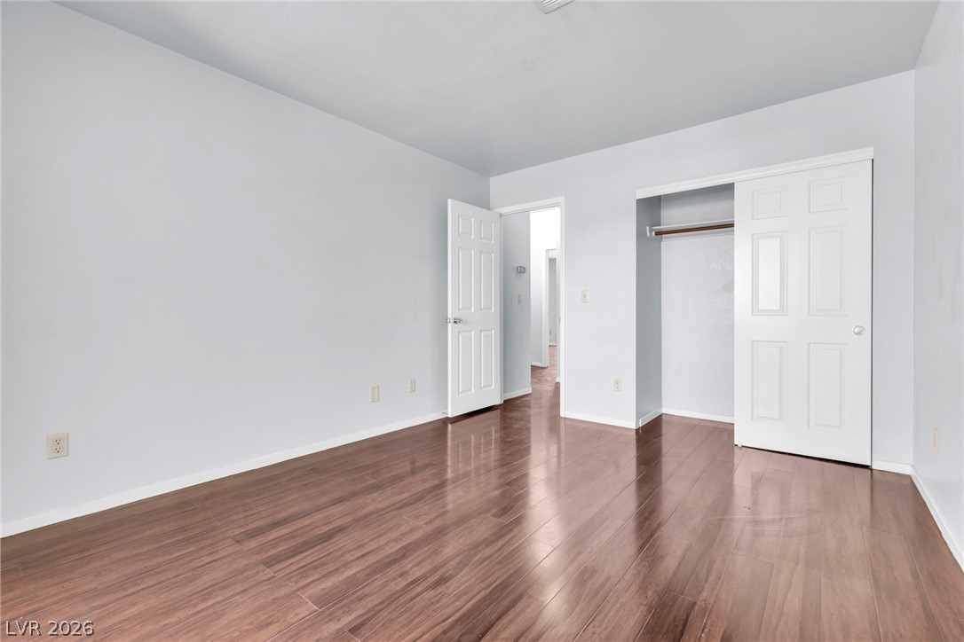 6250 West Flamingo Road, Unit 98 Las Vegas, NV 89103 - Photo 22 of 40 Unfurnished bedroom with dark wood finished floors, baseboards, and a closet