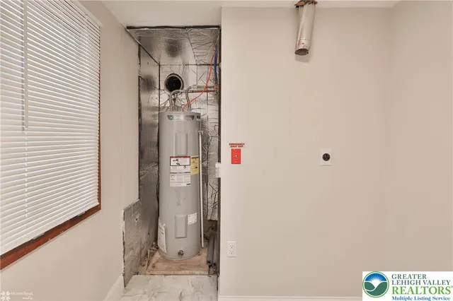 an empty room with wooden floor cabinet and windows