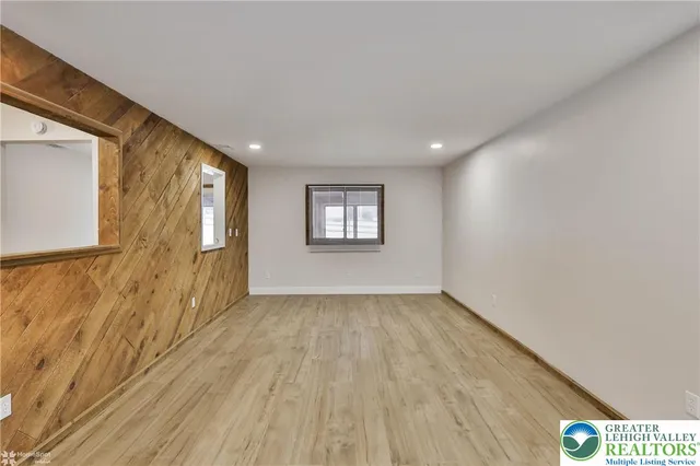 a view of an empty room and a window with wooden floor